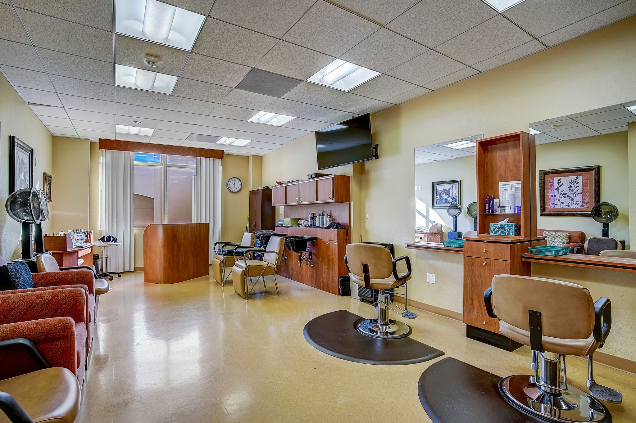 A salon with chairs and a TV in the background.