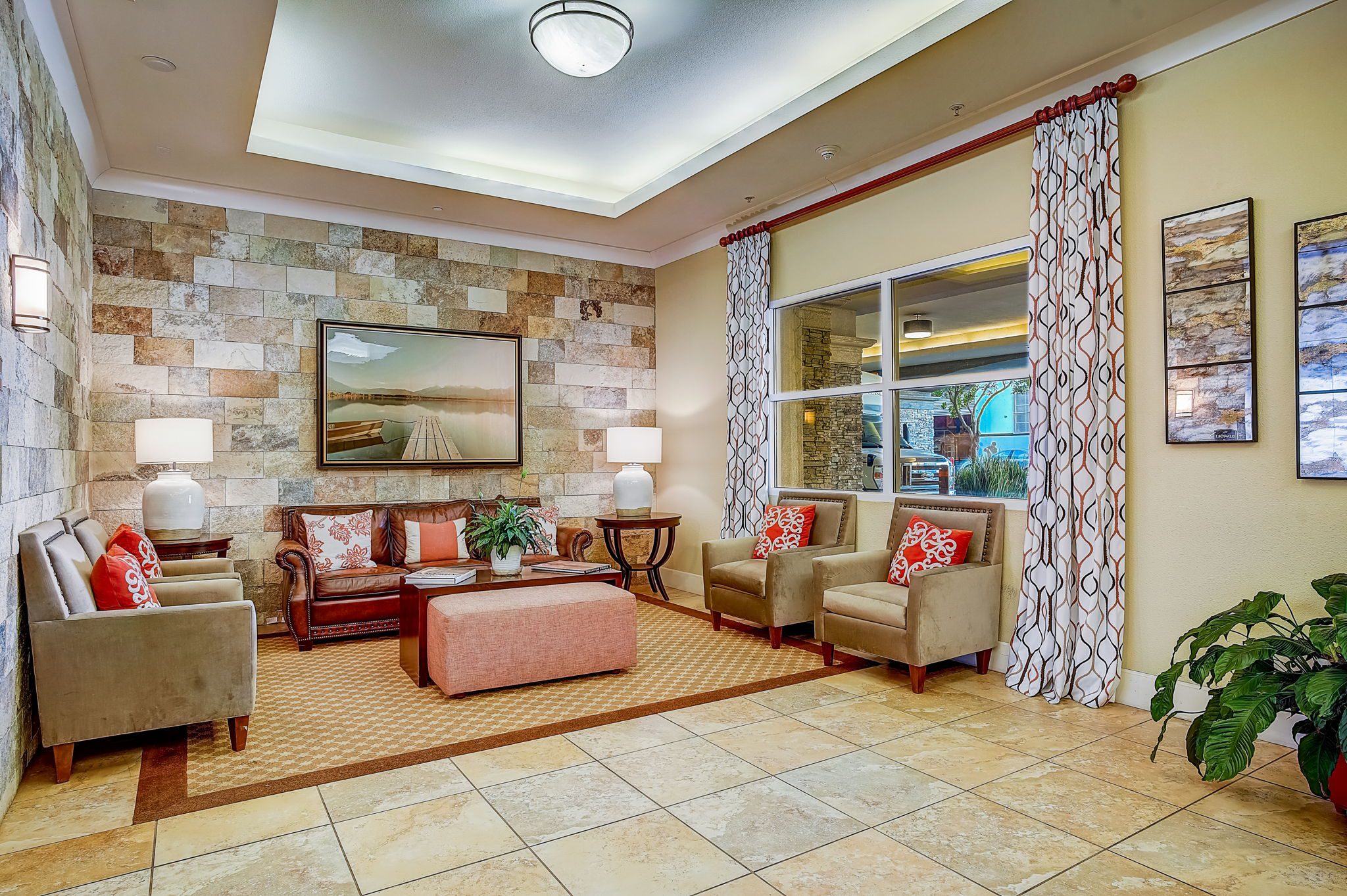The hotel lobby showcases stone walls and a sizable flat screen TV.