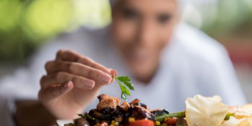 chef putting garnish on a healthy dish