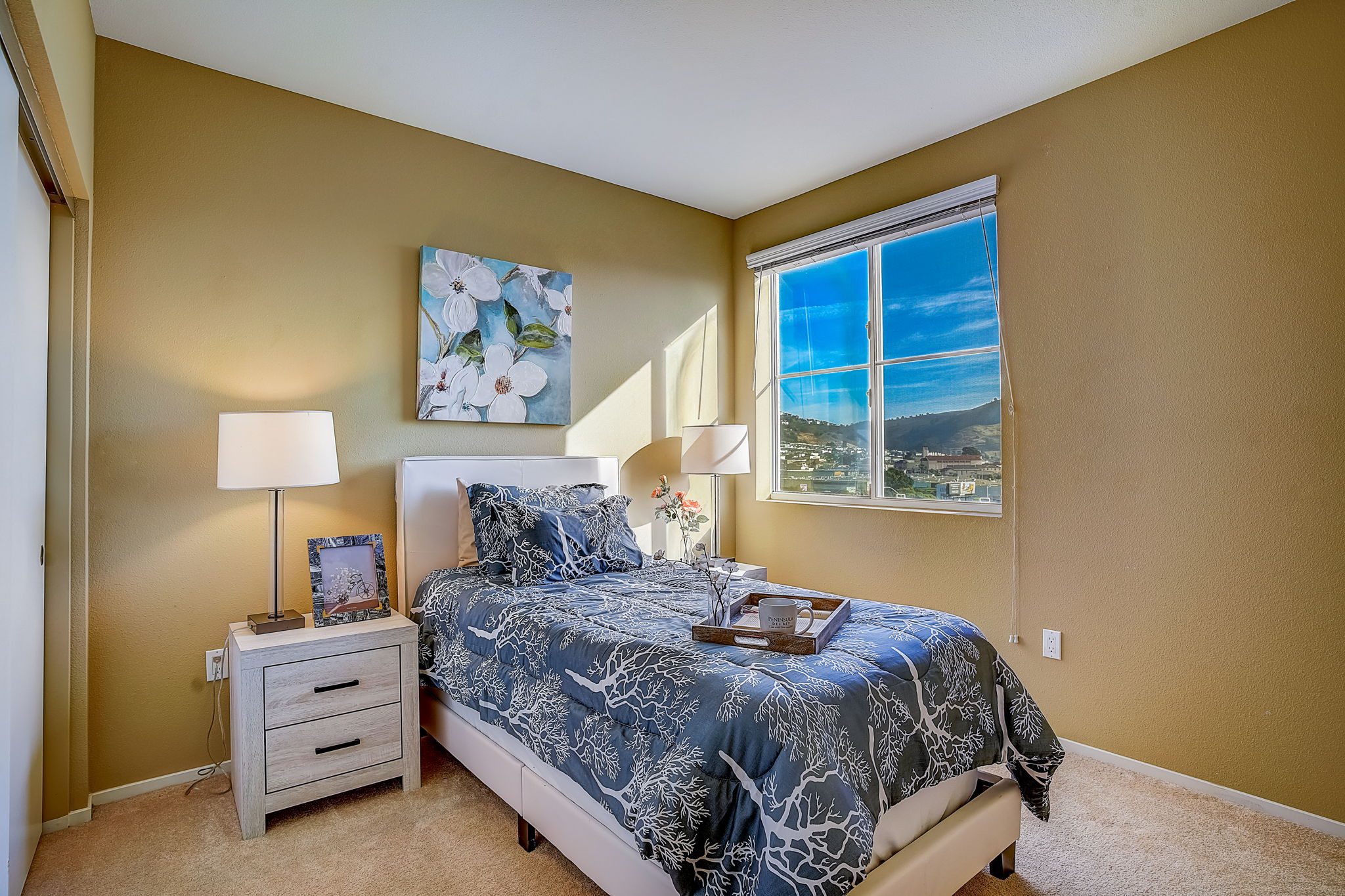 A cozy bedroom with a comfortable bed, nightstands, and a window offering natural light.