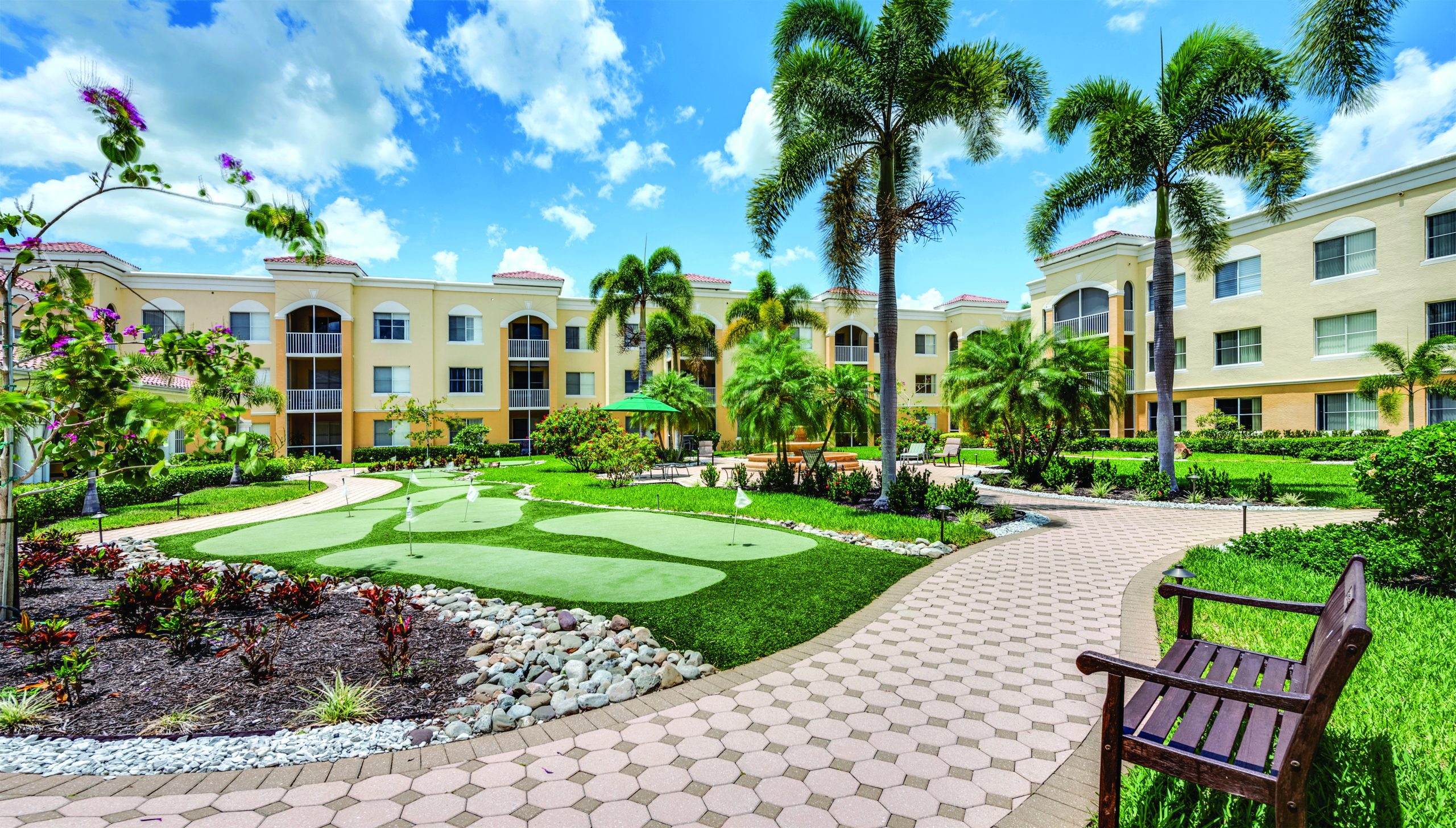 Luxurious courtyard view of a senior living community with landscaping and seating areas