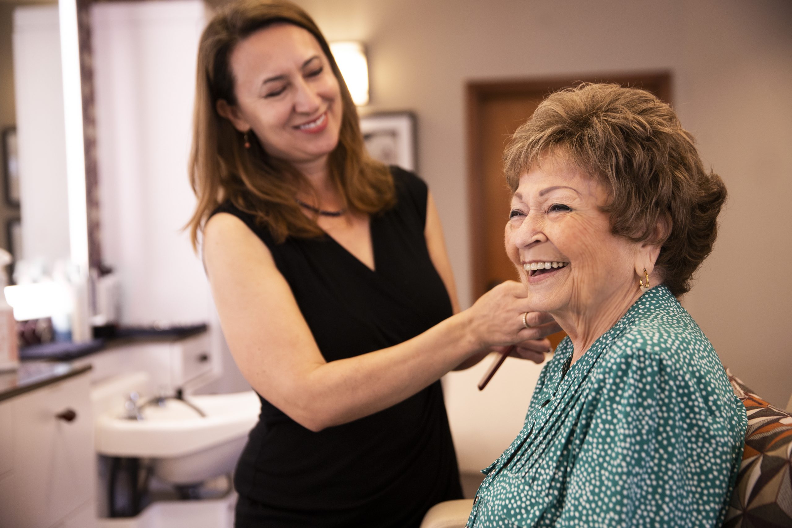 elderly woman getting her hair done in a salon by a stylist