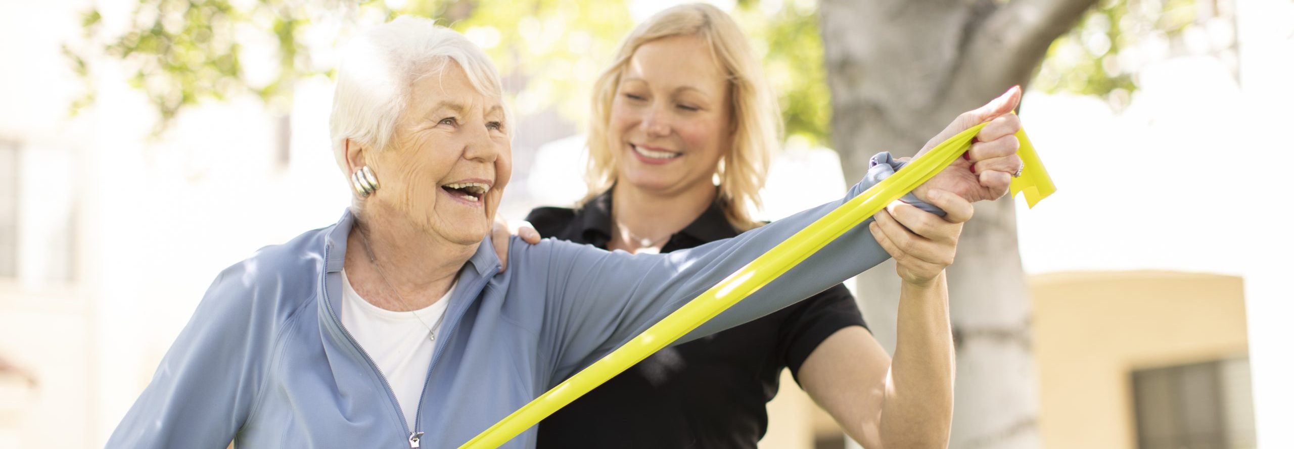 an elderly woman being assisted by a fitness coach on her exercise