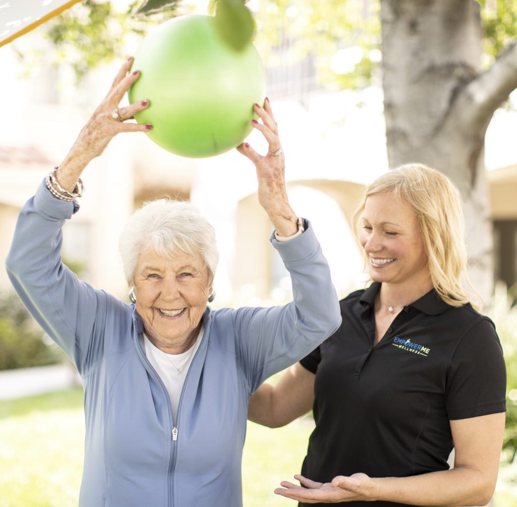 Senior holding a green ball over her head