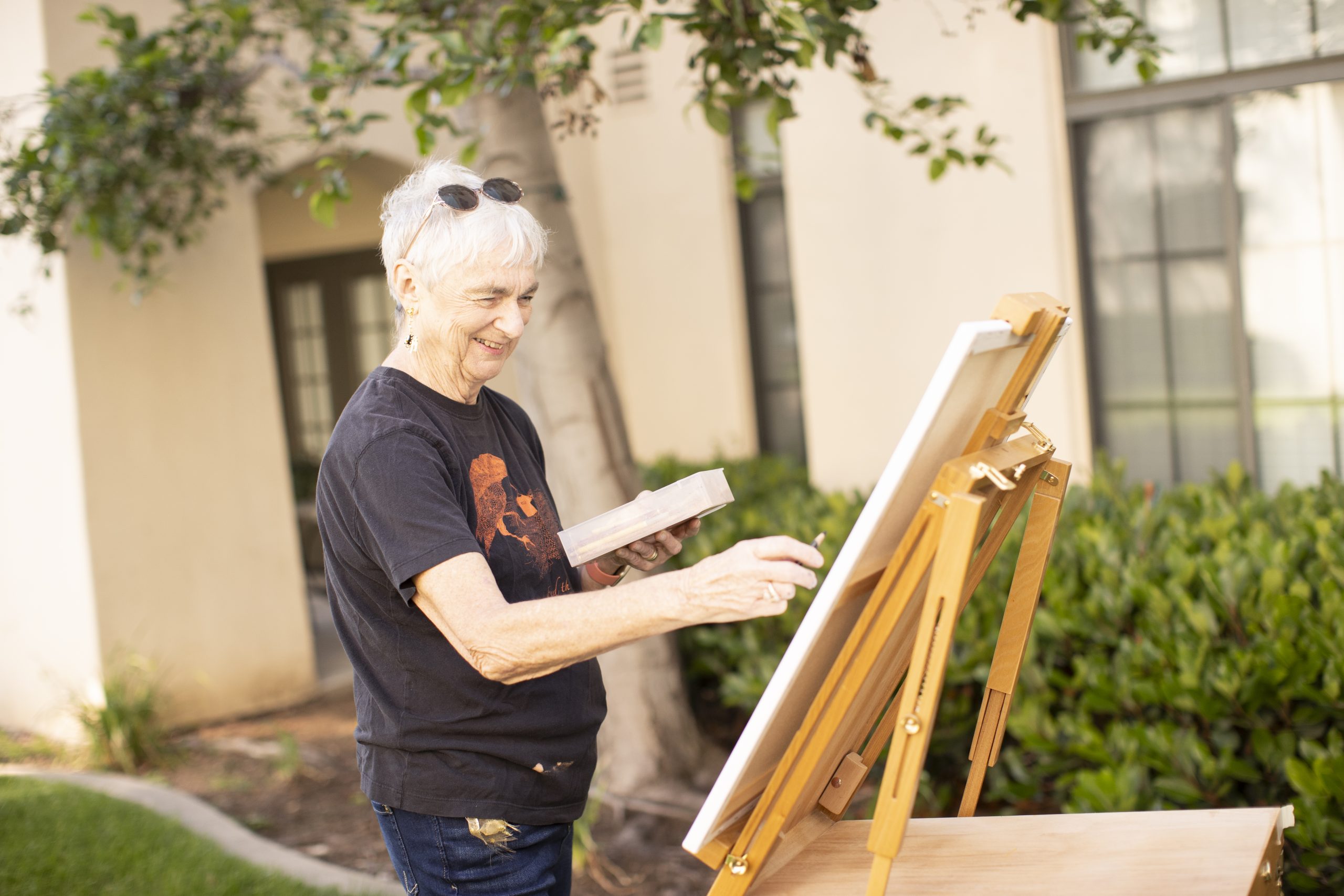 elderly woman painting in the courtyard