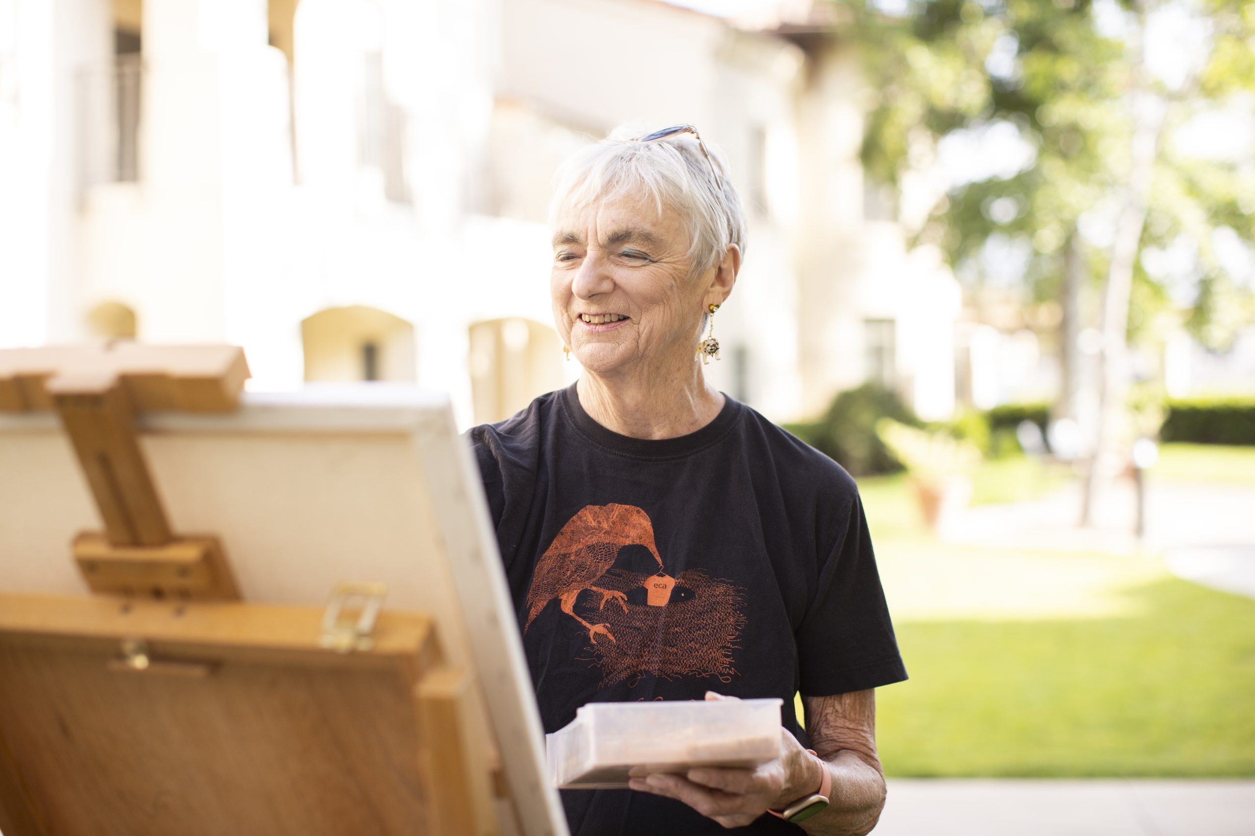 Elderly Woman Painting in Retirement community courtyard