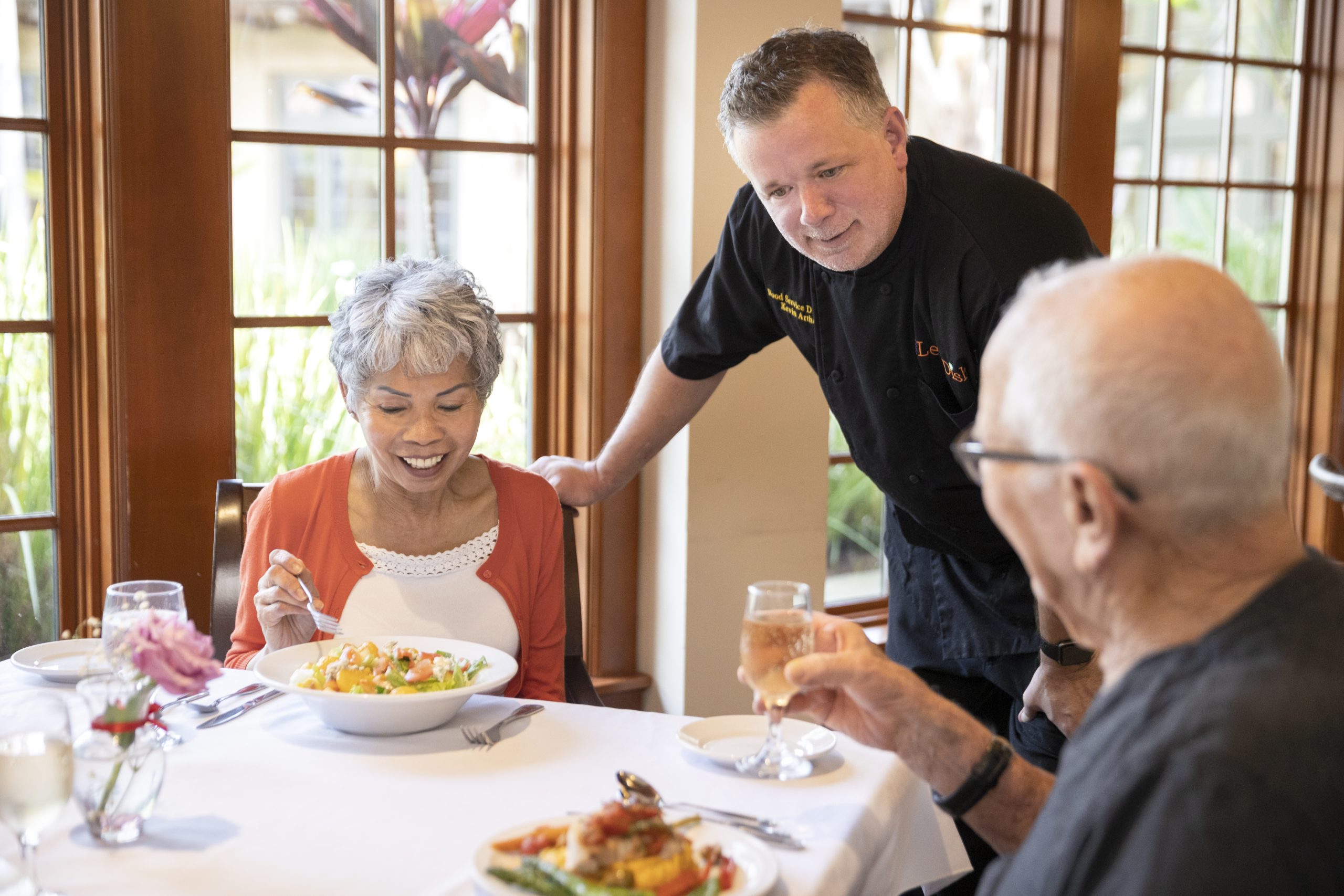 two elderly people eating and the chef is asking them if everything is ok