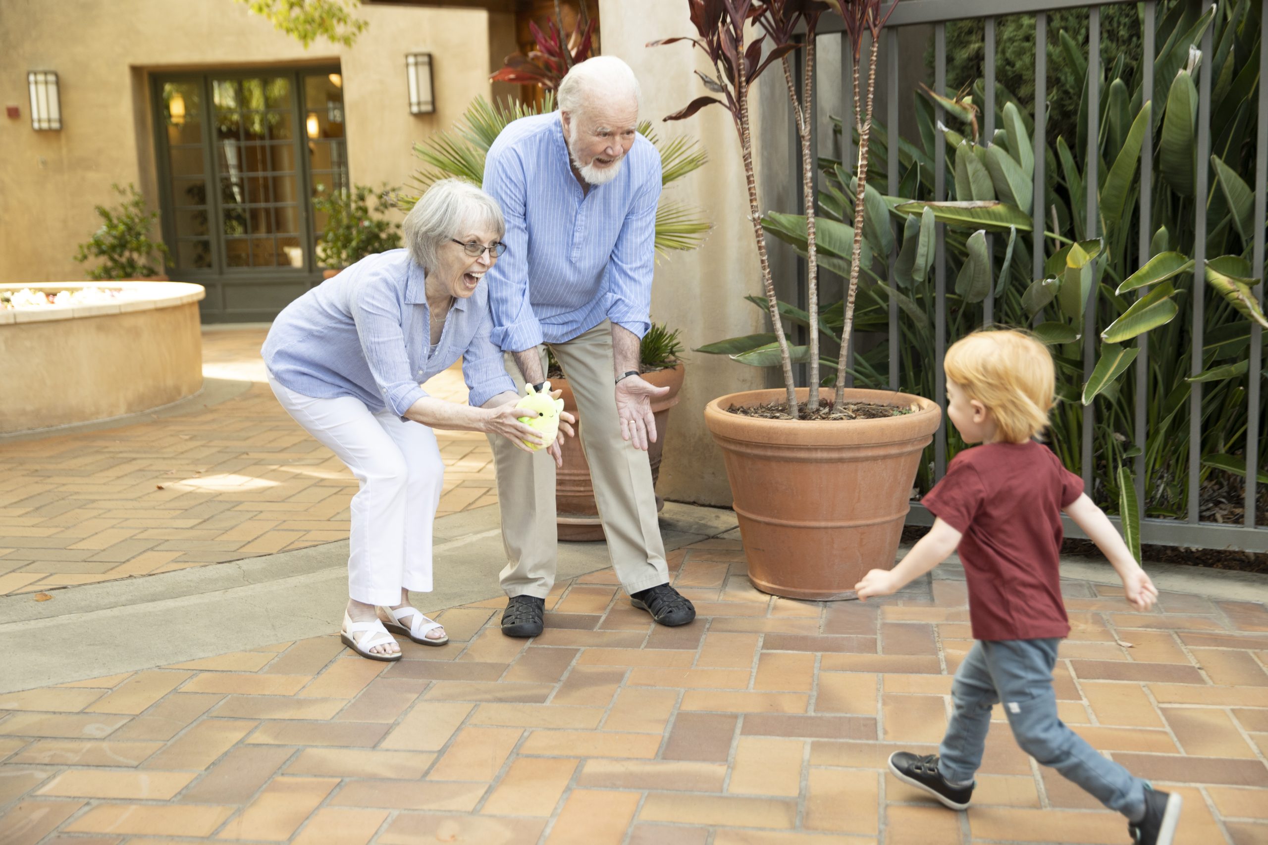 A couple joyfully engages with a child, playing together and creating cherished memories.