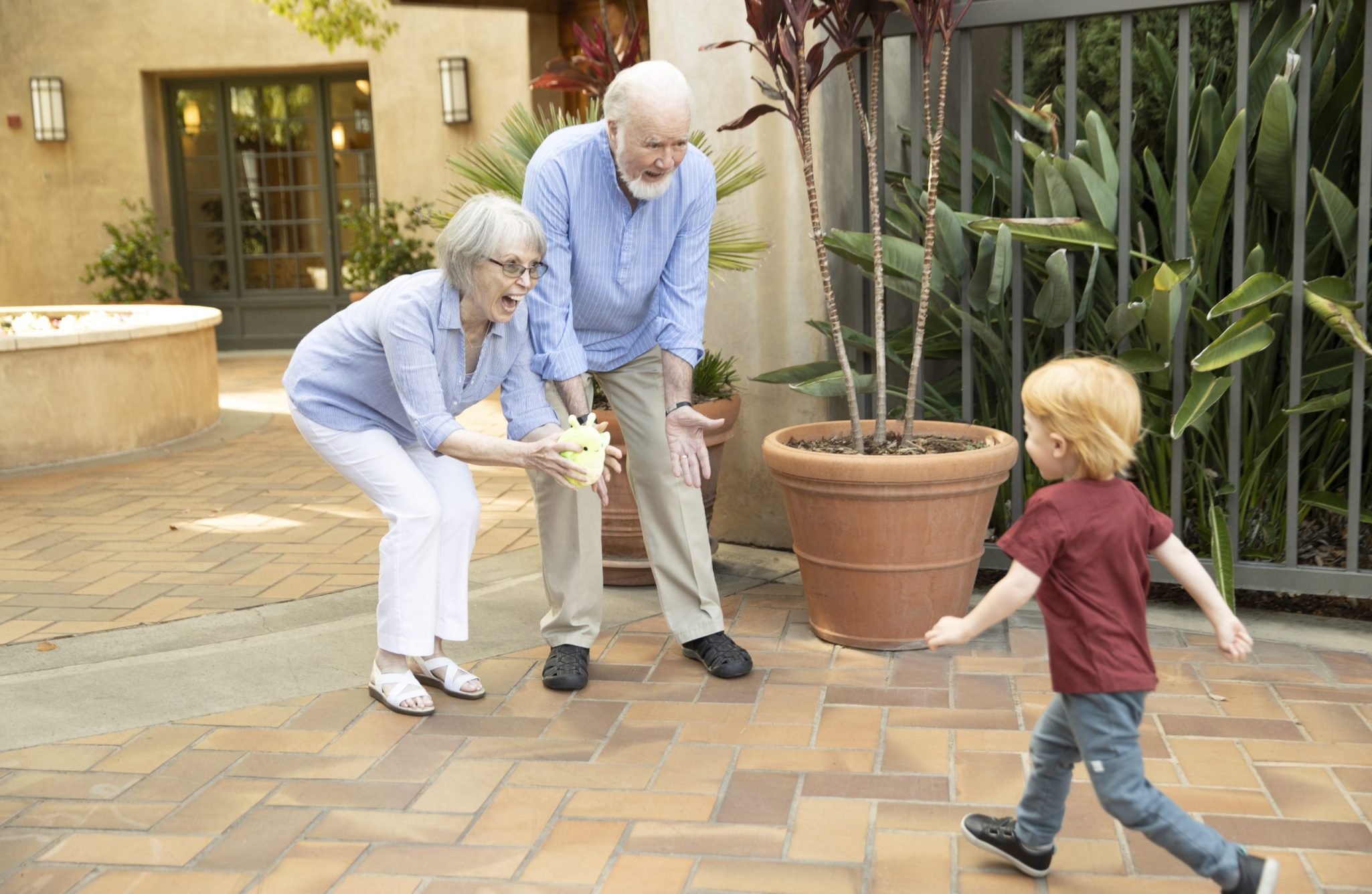 two grandparents seeing their grandson coming towards them