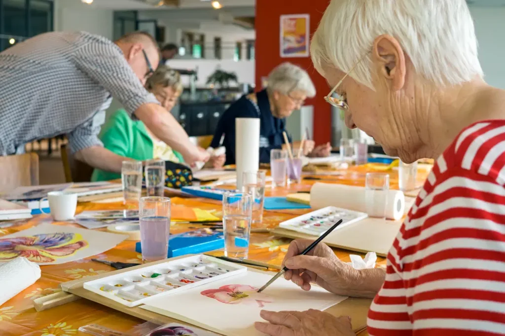 seniors painting at a table together