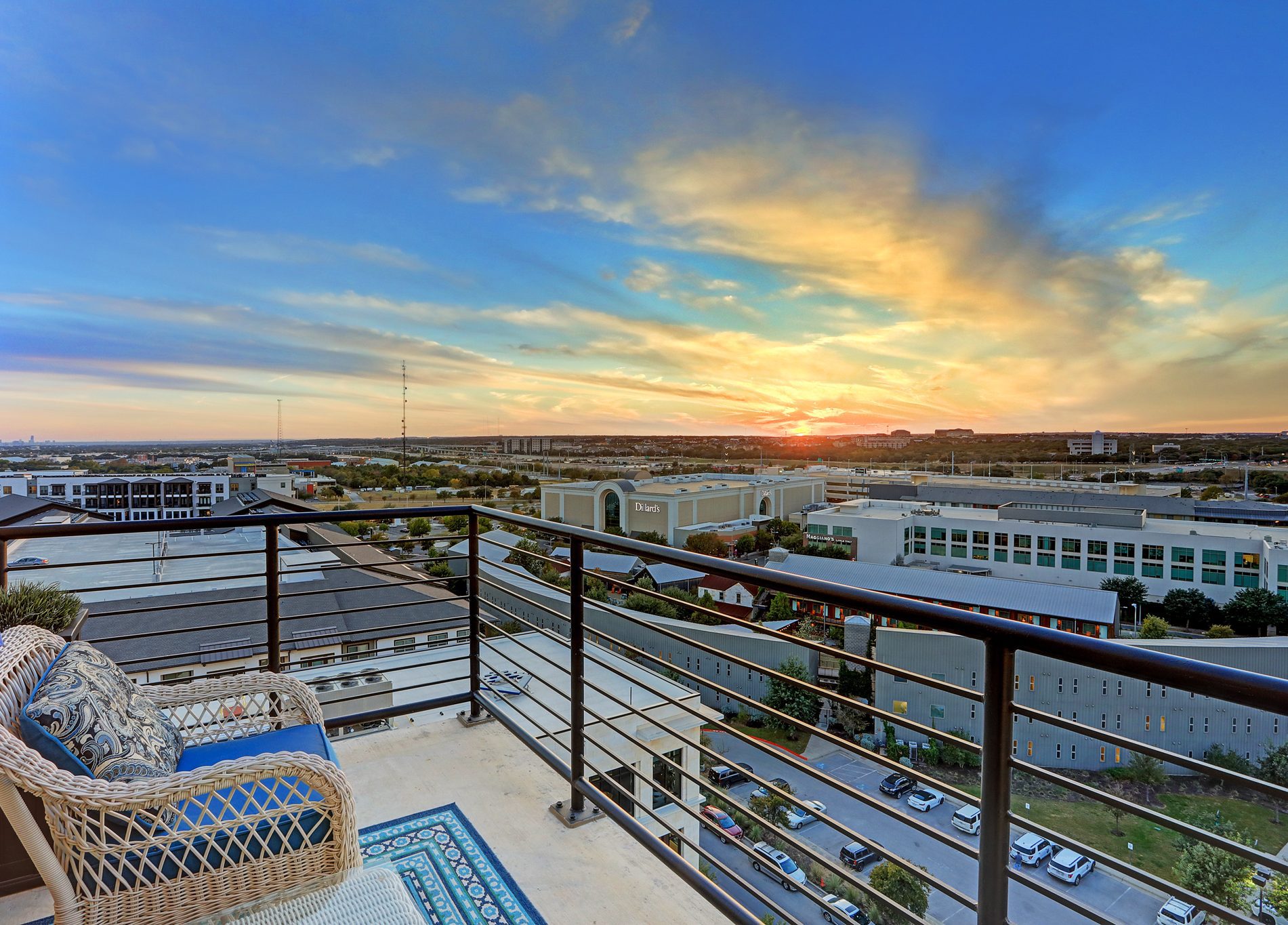 A cityscape view from a balcony with a table and chair. Enjoy the urban scenery while relaxing.