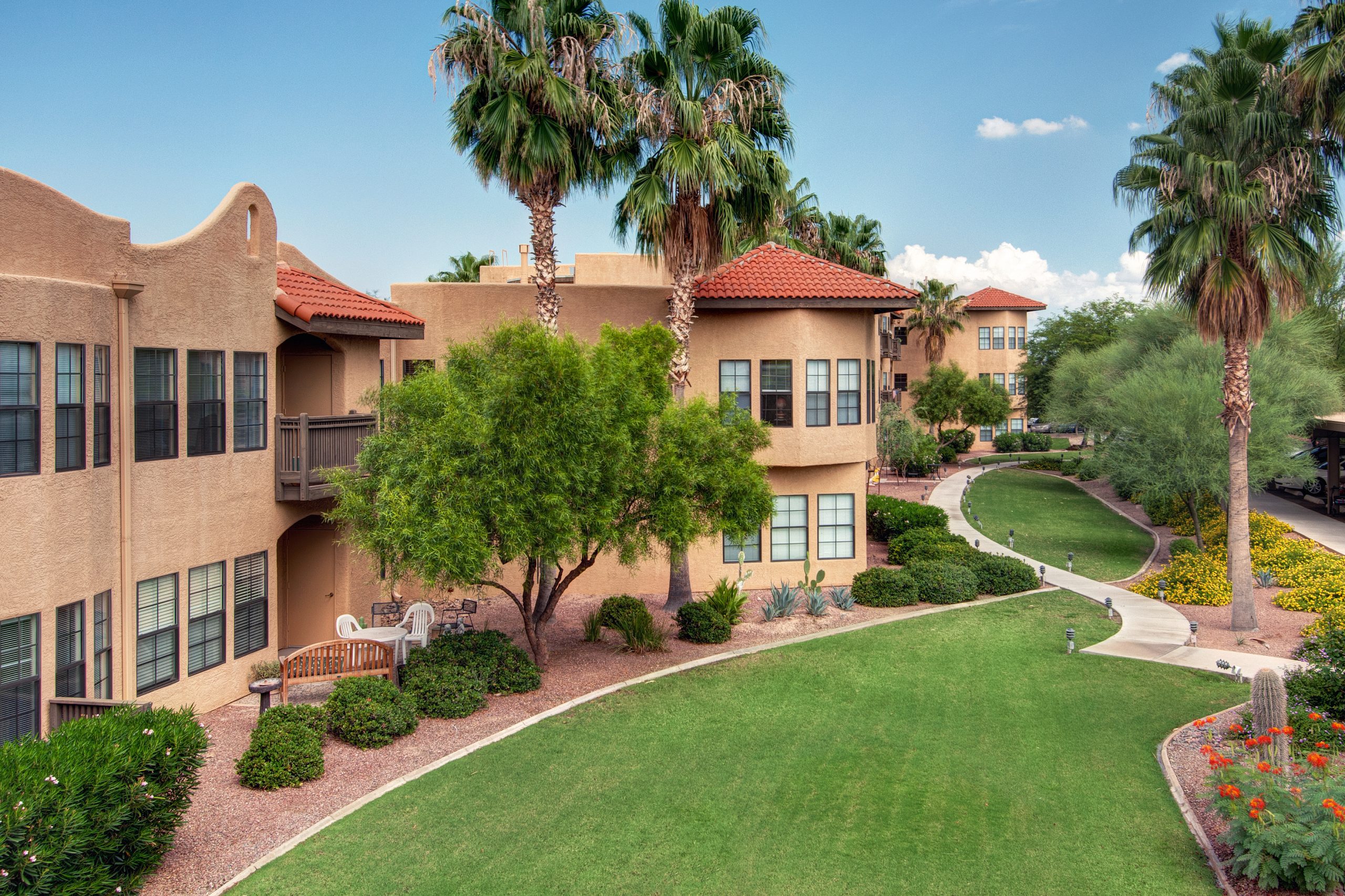 Exterior of a community complex surrounded by vibrant green grass, creating a serene and inviting atmosphere.