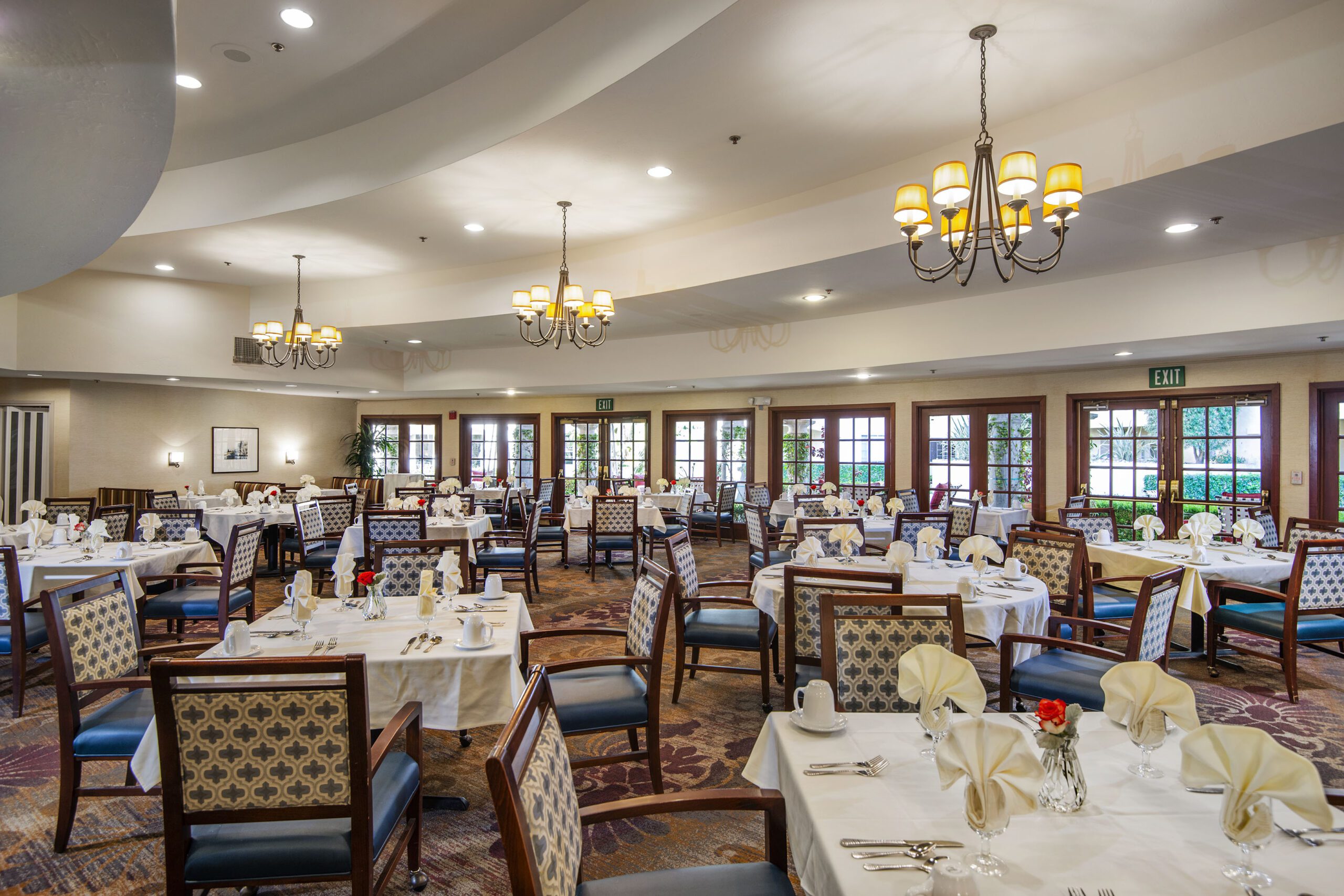 A spacious dining room with neatly arranged tables and chairs for a comfortable dining experience.