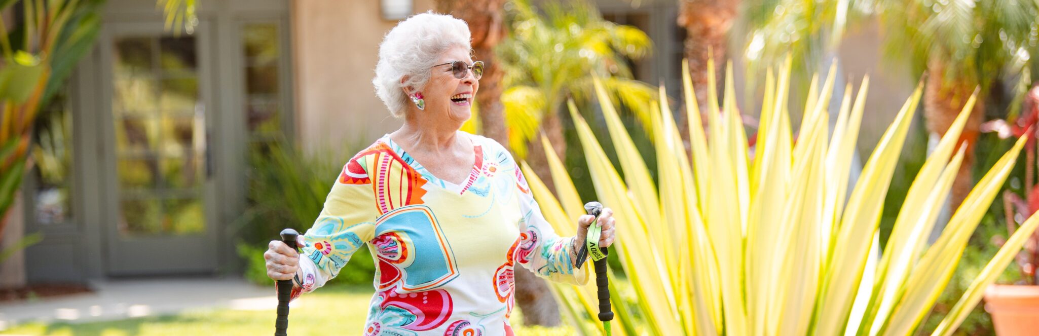 smiling active elderly woman going for a walk with walking sticks