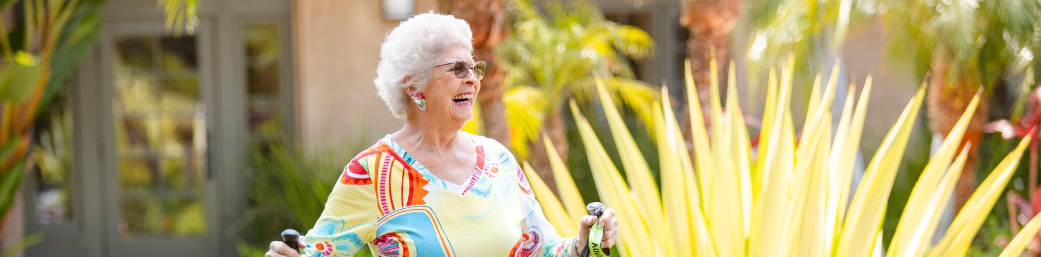 smiling active elderly woman going for a walk with walking sticks