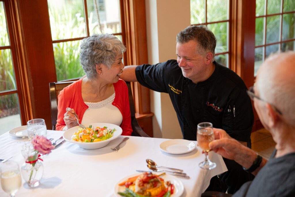 Seniors enjoying leisure activities in a brightly lit room with large windows.