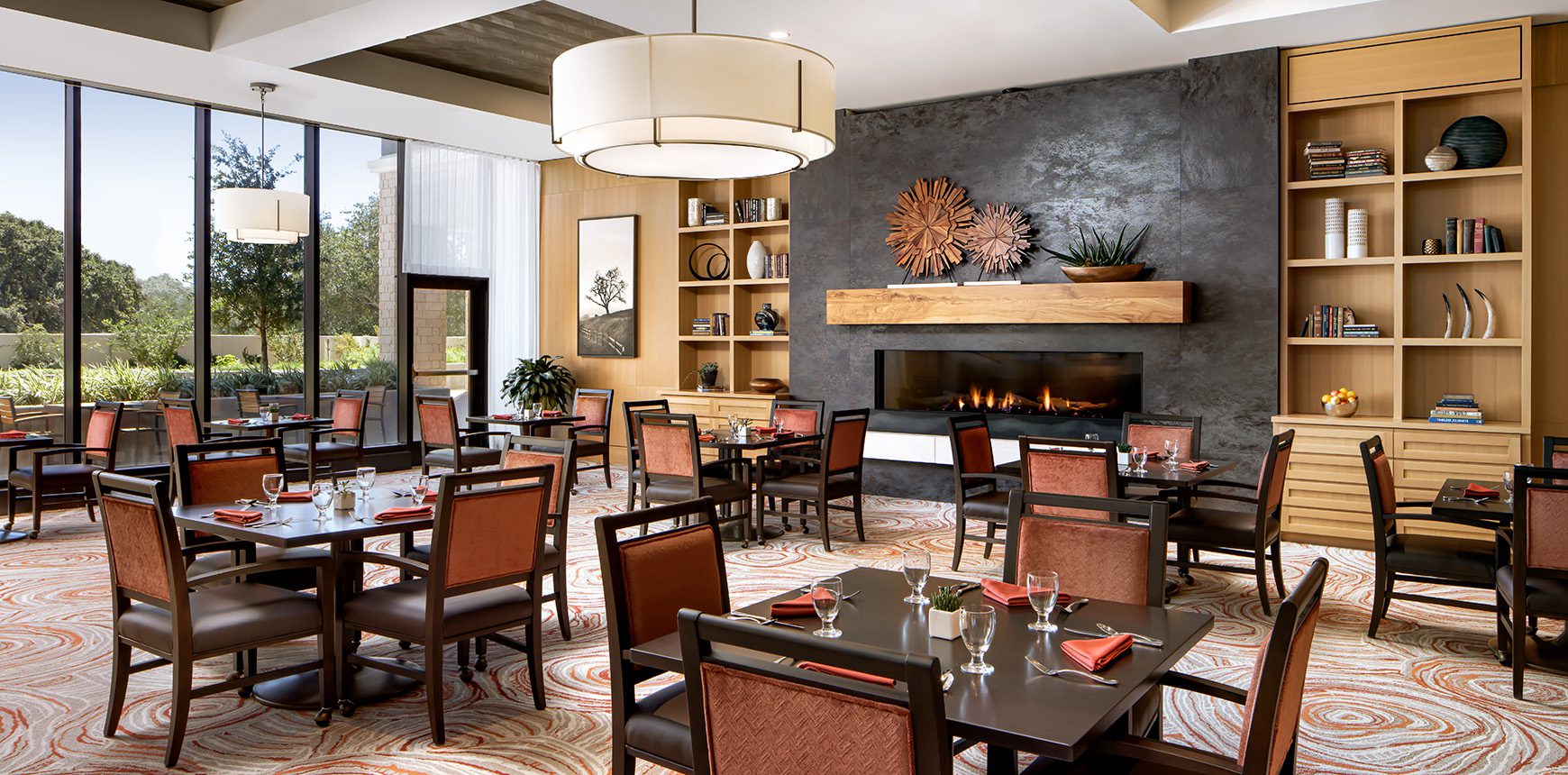 A cozy restaurant with a warm fireplace and neatly arranged tables, creating a welcoming ambiance.