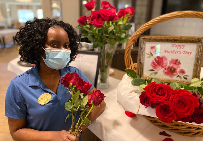 A woman wearing a face mask holds a bouquet of roses, symbolizing love and protection.