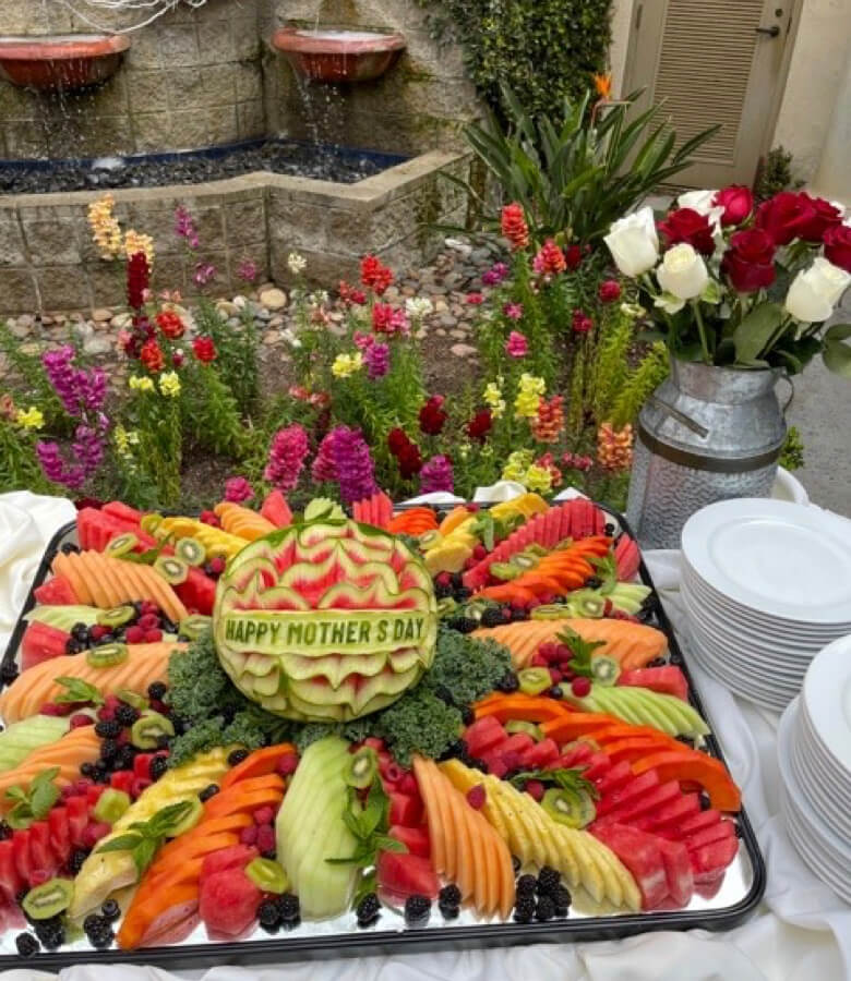 A beautiful arrangement of fresh fruit and vibrant flowers displayed on a table.