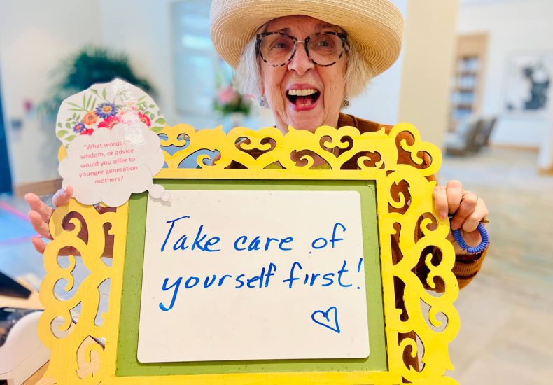 An older woman holds a sign that reads 