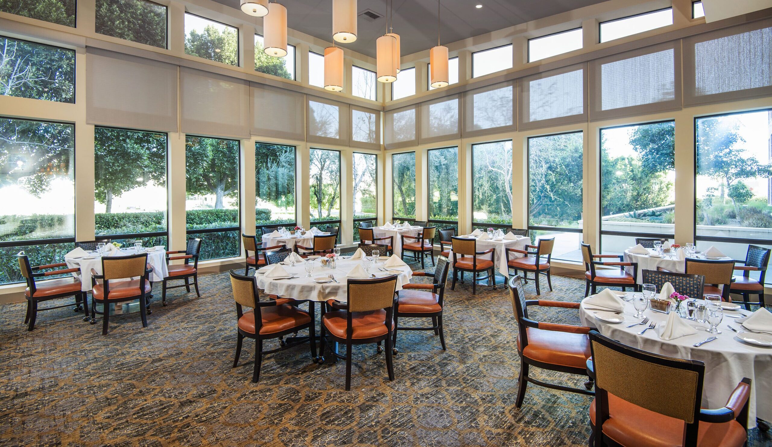 the upscale dining room at the village northridge with loft ceilings and floor to ceiling windows