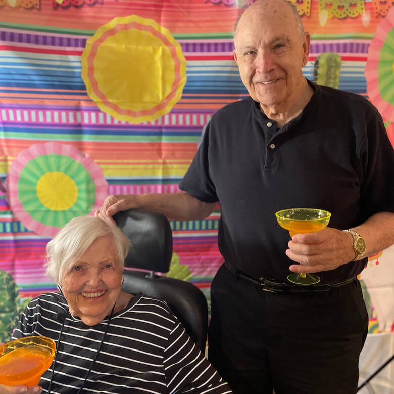 An elderly couple enjoying refreshing drinks together, showcasing their bond and relaxation.