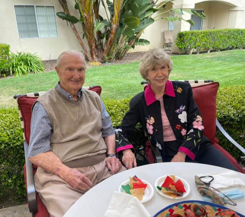 An elderly couple enjoying a meal together at a table, savoring the food and each other's company.