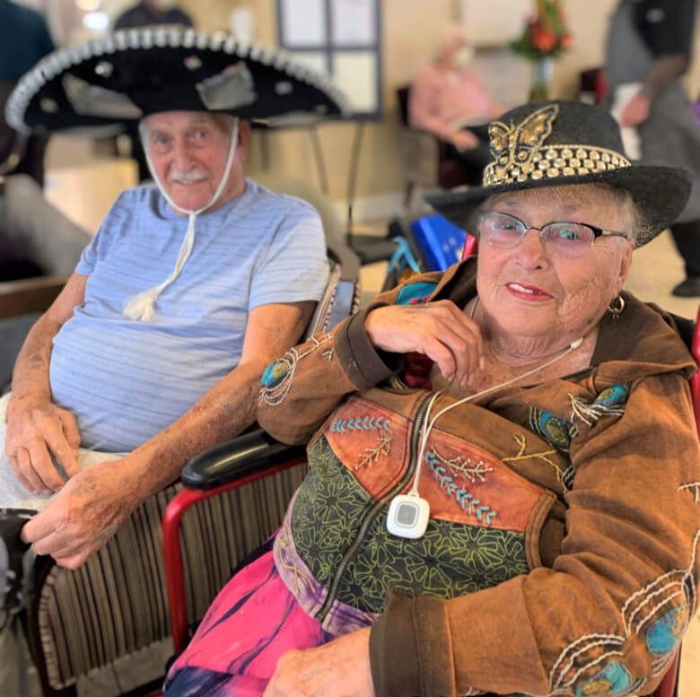 An older couple joyfully wearing traditional Mexican hats, showcasing their vibrant cultural spirit.