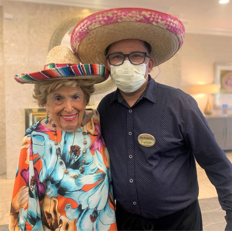 A couple wearing sombreros happily pose for a photo, showcasing their cultural appreciation and joyful spirit.