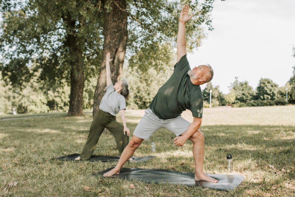 An elderly couple doing yoga at SRG Senior Living.