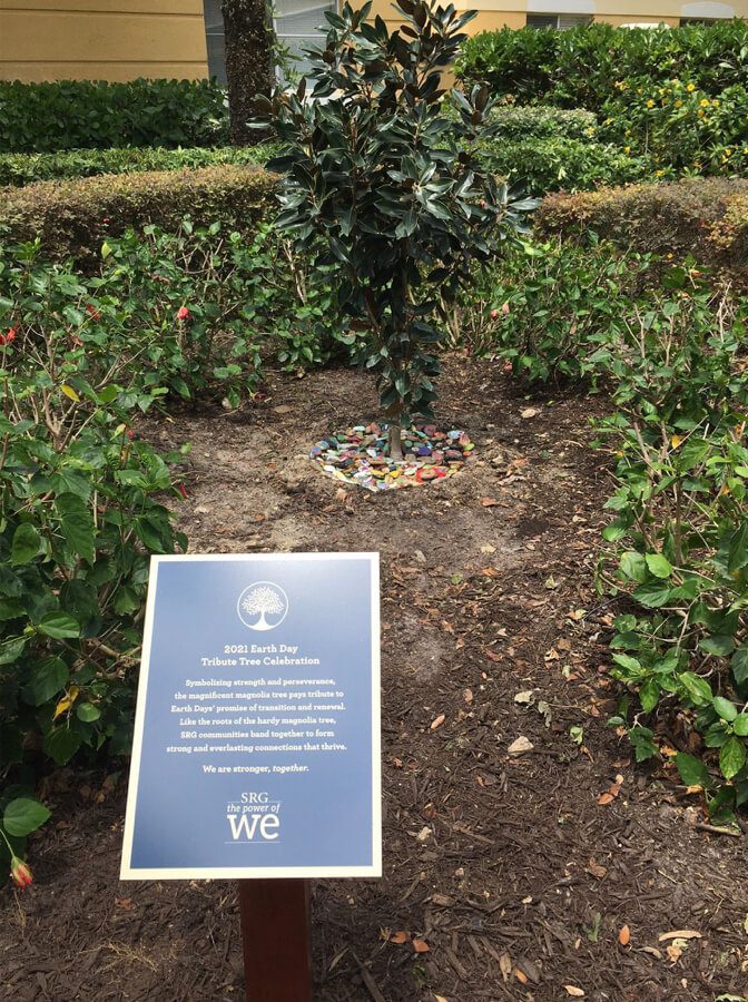 A vibrant image of Earth Day celebration with people planting trees and flowers in a garden.