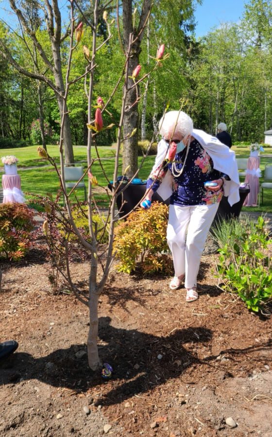 A woman in formal attire planting a tree together, symbolizing her commitment to the environment and a sustainable future.