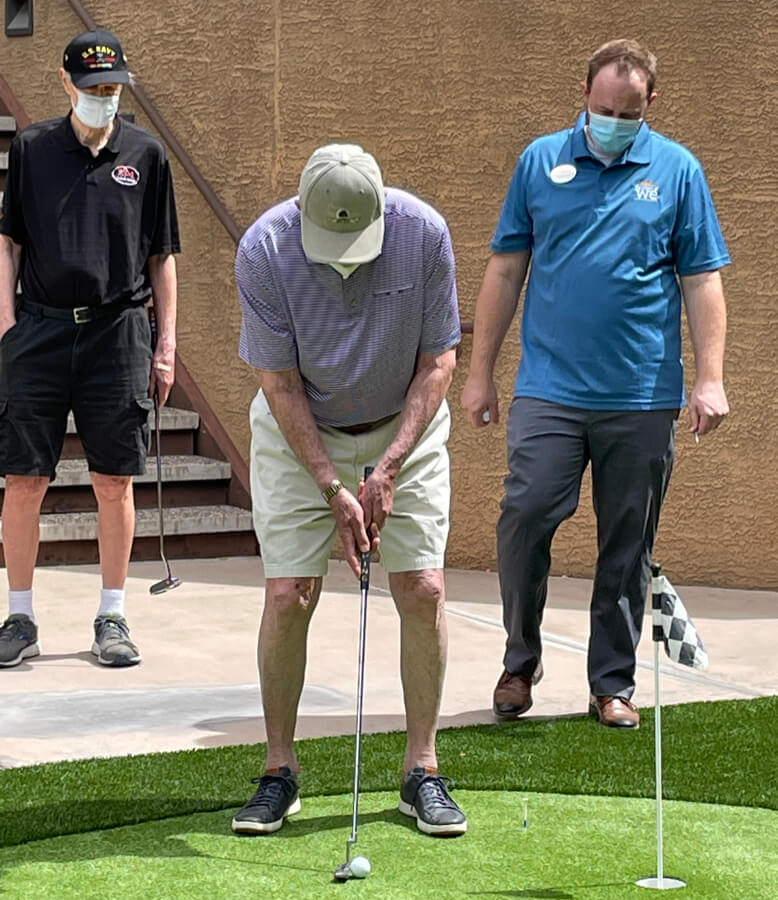 A man wearing a mask and playing golf.