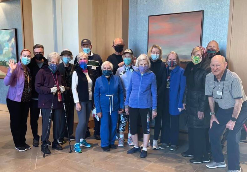 A diverse group of individuals wearing face masks and holding walking sticks for support.