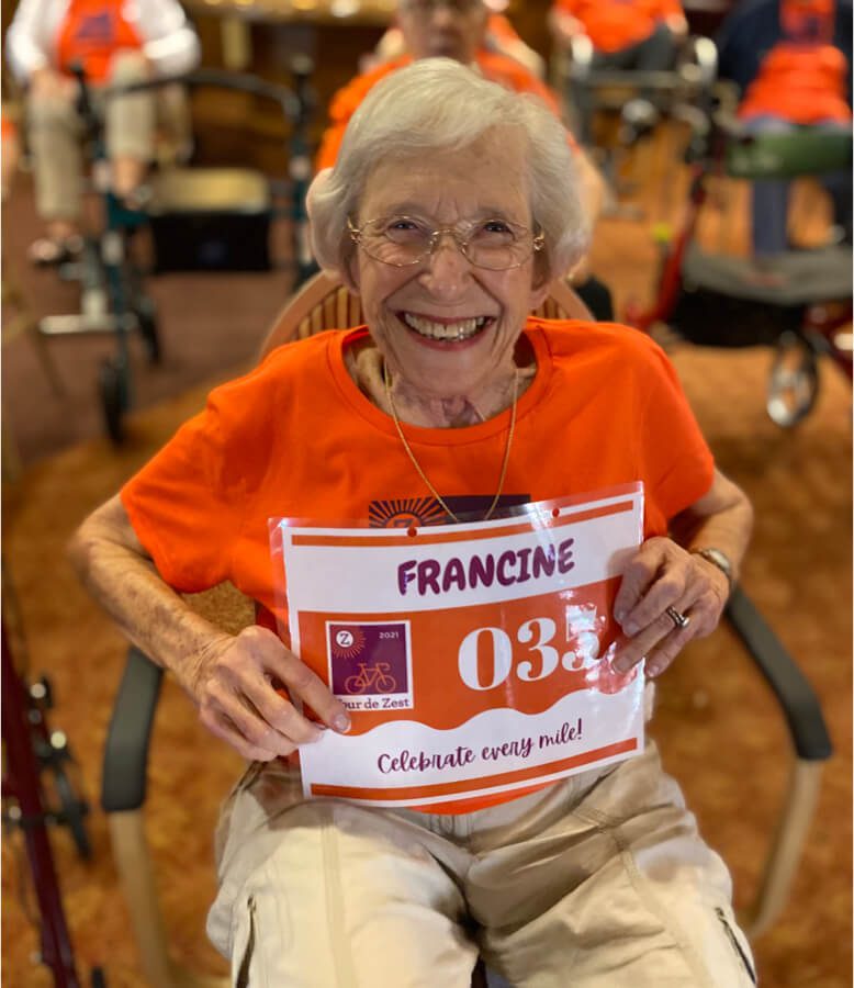 An elderly woman proudly displaying a sign that reads 