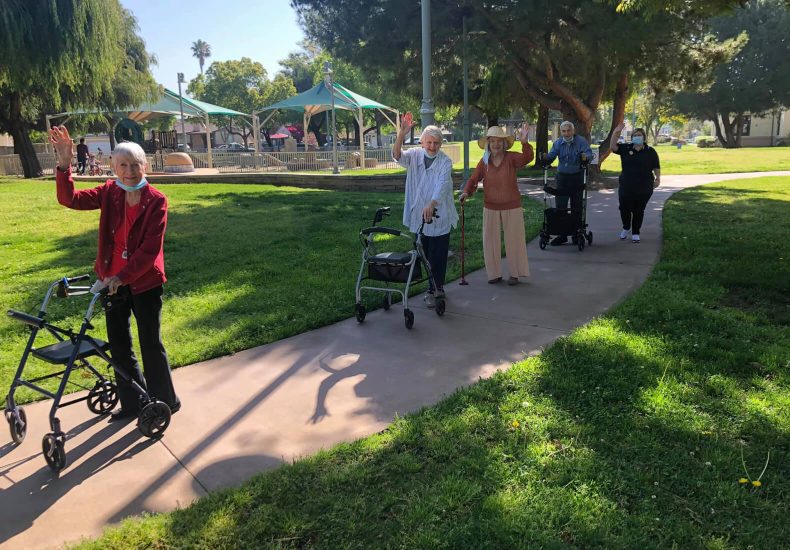 A group of people using walkers walking down a path together.