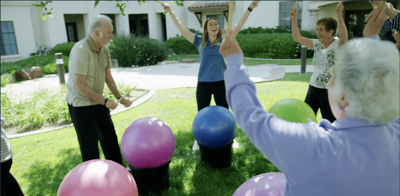 Seniors drumming on a ball