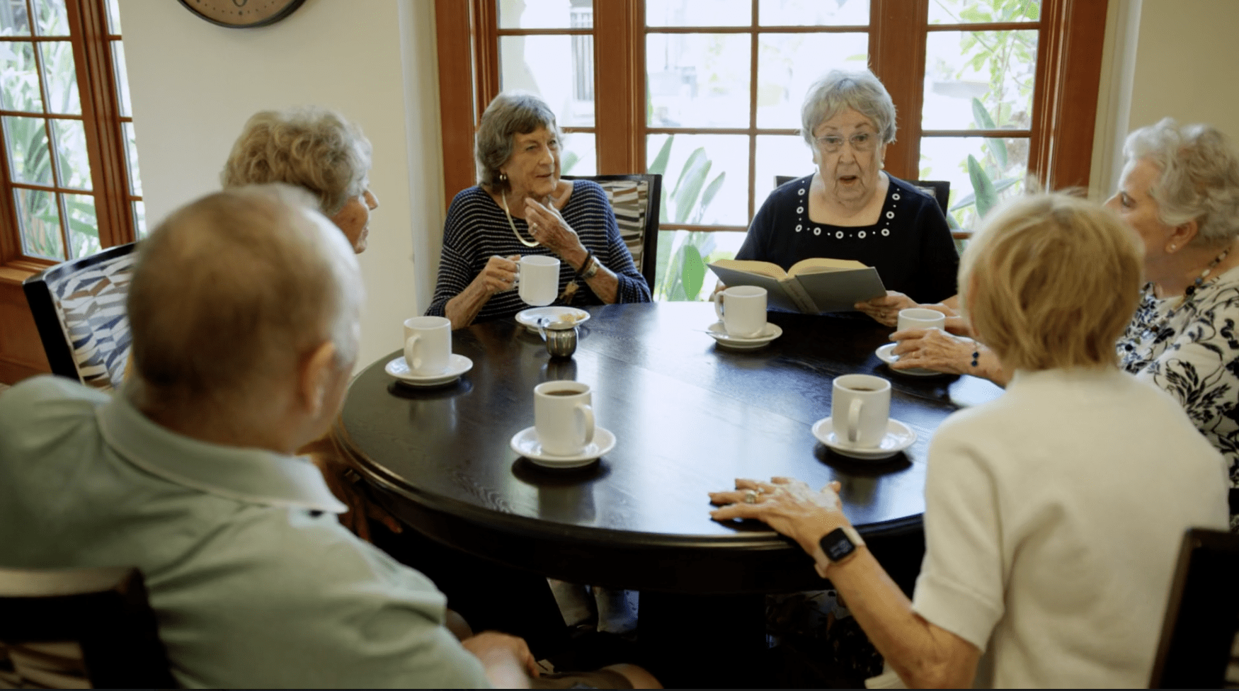 Seniors talking about a book over coffee
