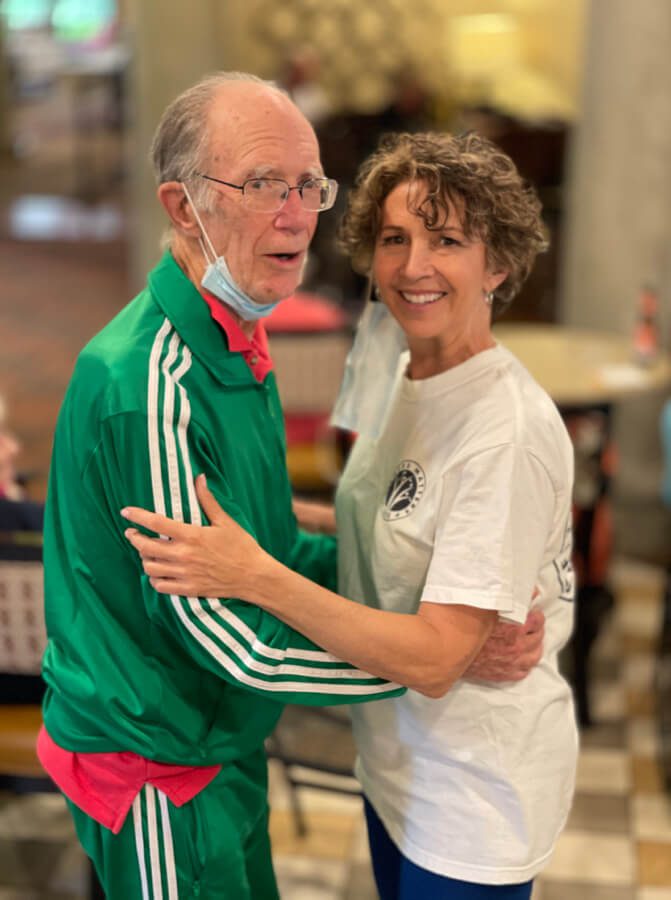 An elderly couple sharing a heartfelt embrace in a cozy restaurant, expressing their love and affection.