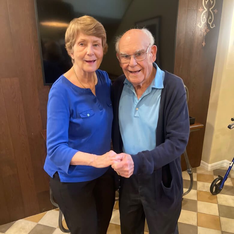 An older couple shaking hands in a room - a heartwarming gesture of mutual respect and agreement.