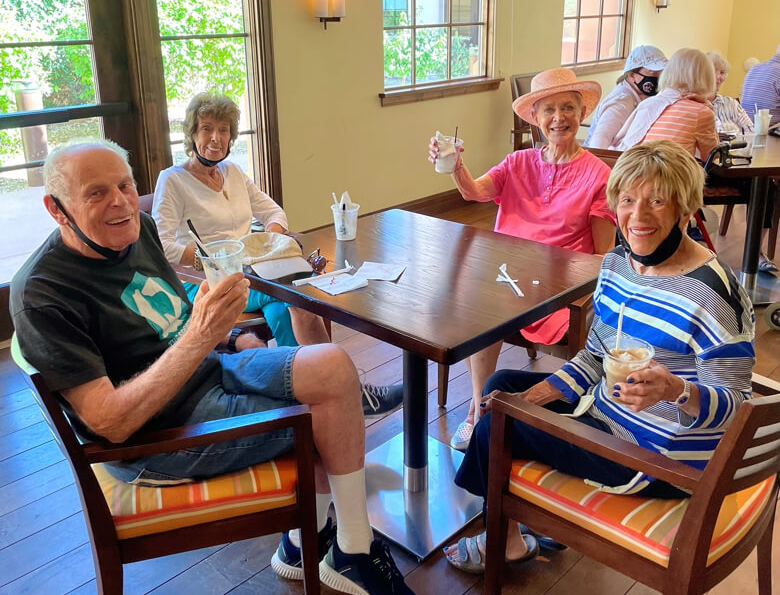 A group of seniors sitting around a table, engaged in conversation and enjoying each other's company.