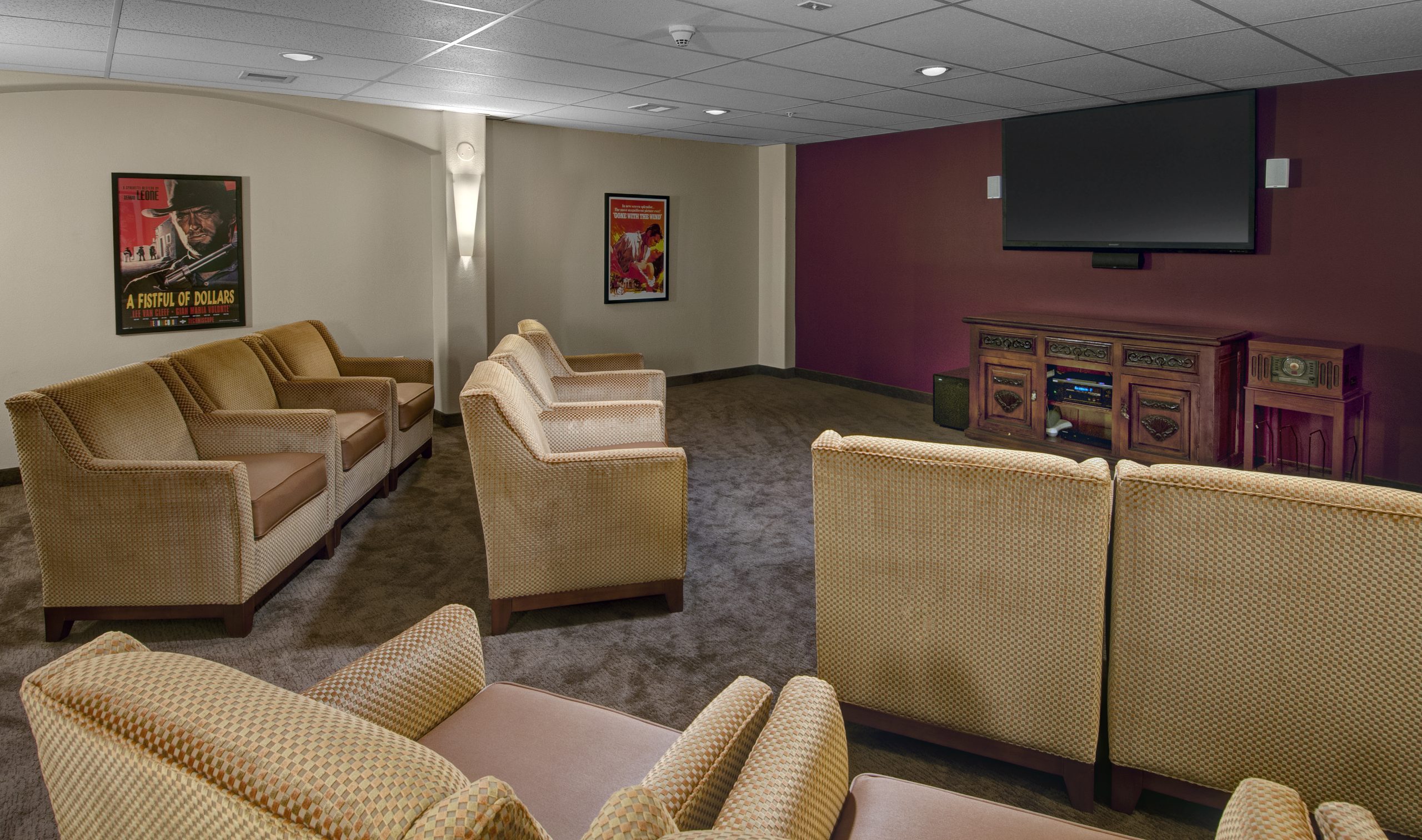movie theater at community with maroon wall and big tv 
