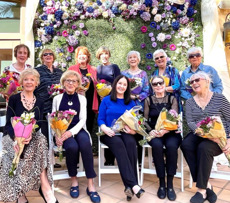 Group of elderly women sitting together with flowers in a mothers day celebration