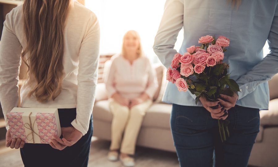 Family celebration with flowers and gift for a senior