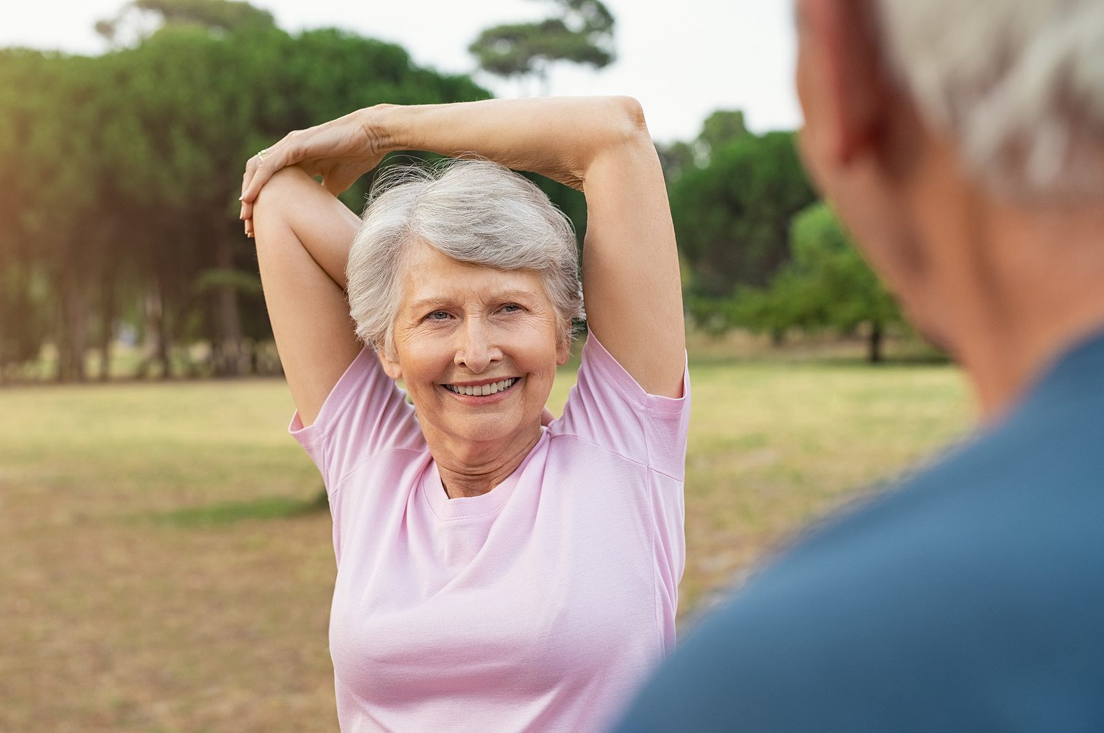 Two seniors stretch as part of an active, independent senior living community