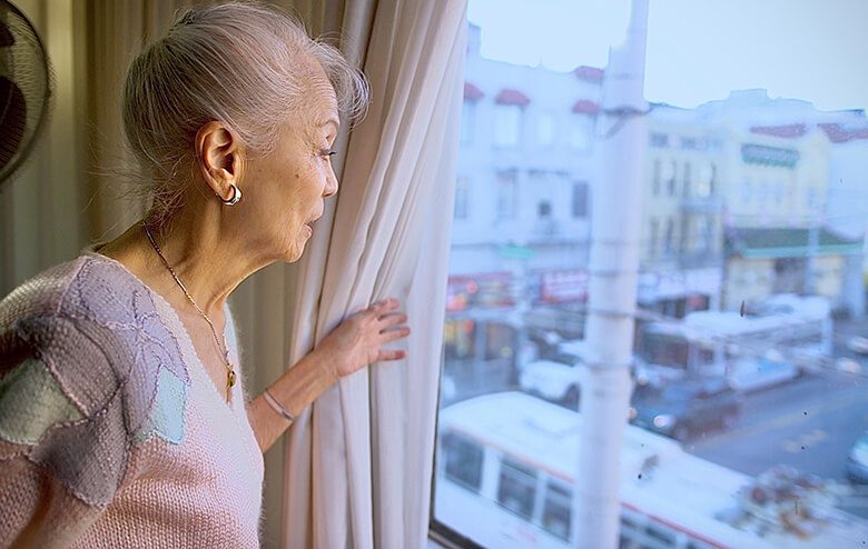 senior woman looking out window