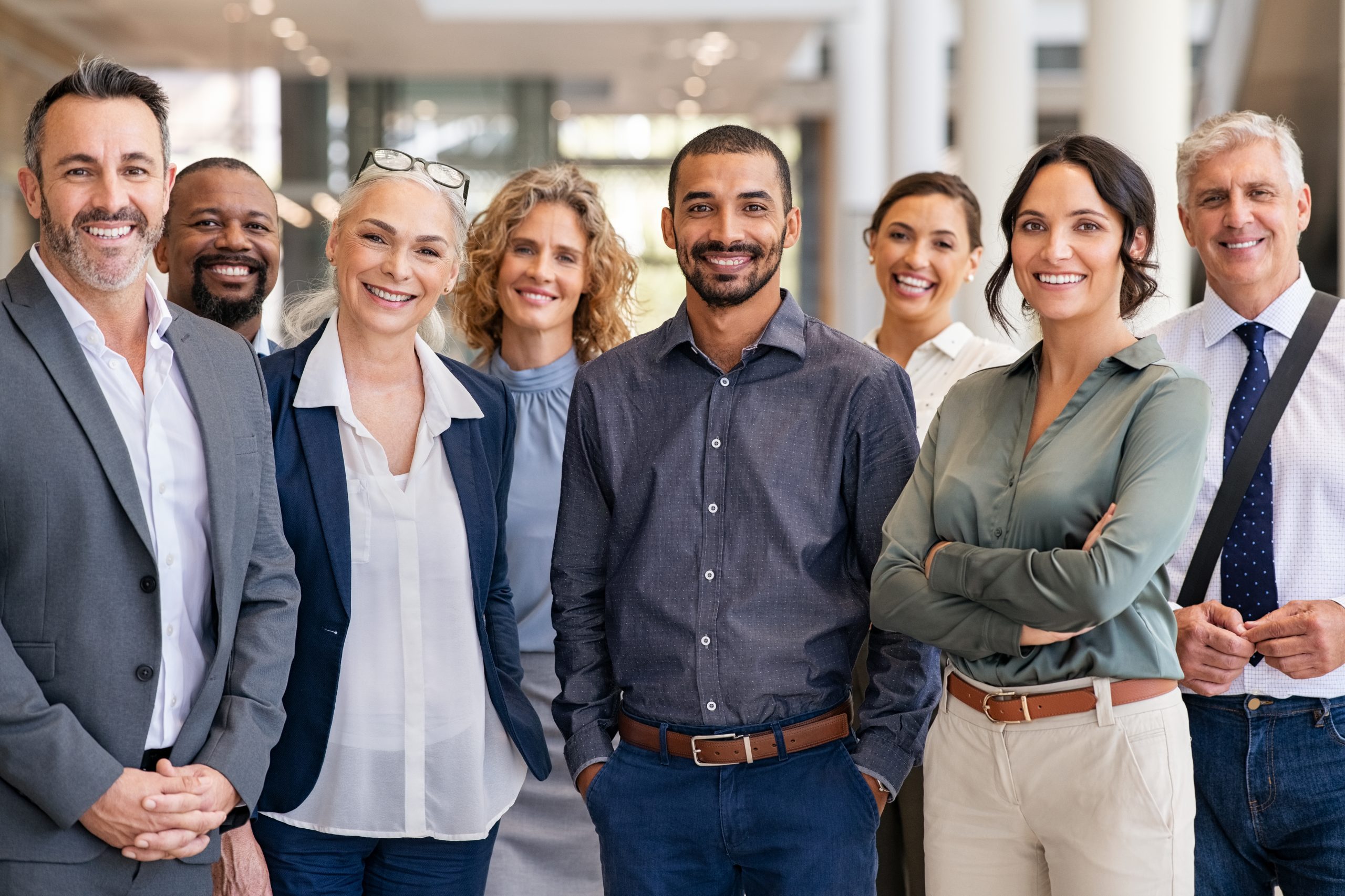 A diverse group of professionals standing together, discussing business matters and collaborating.