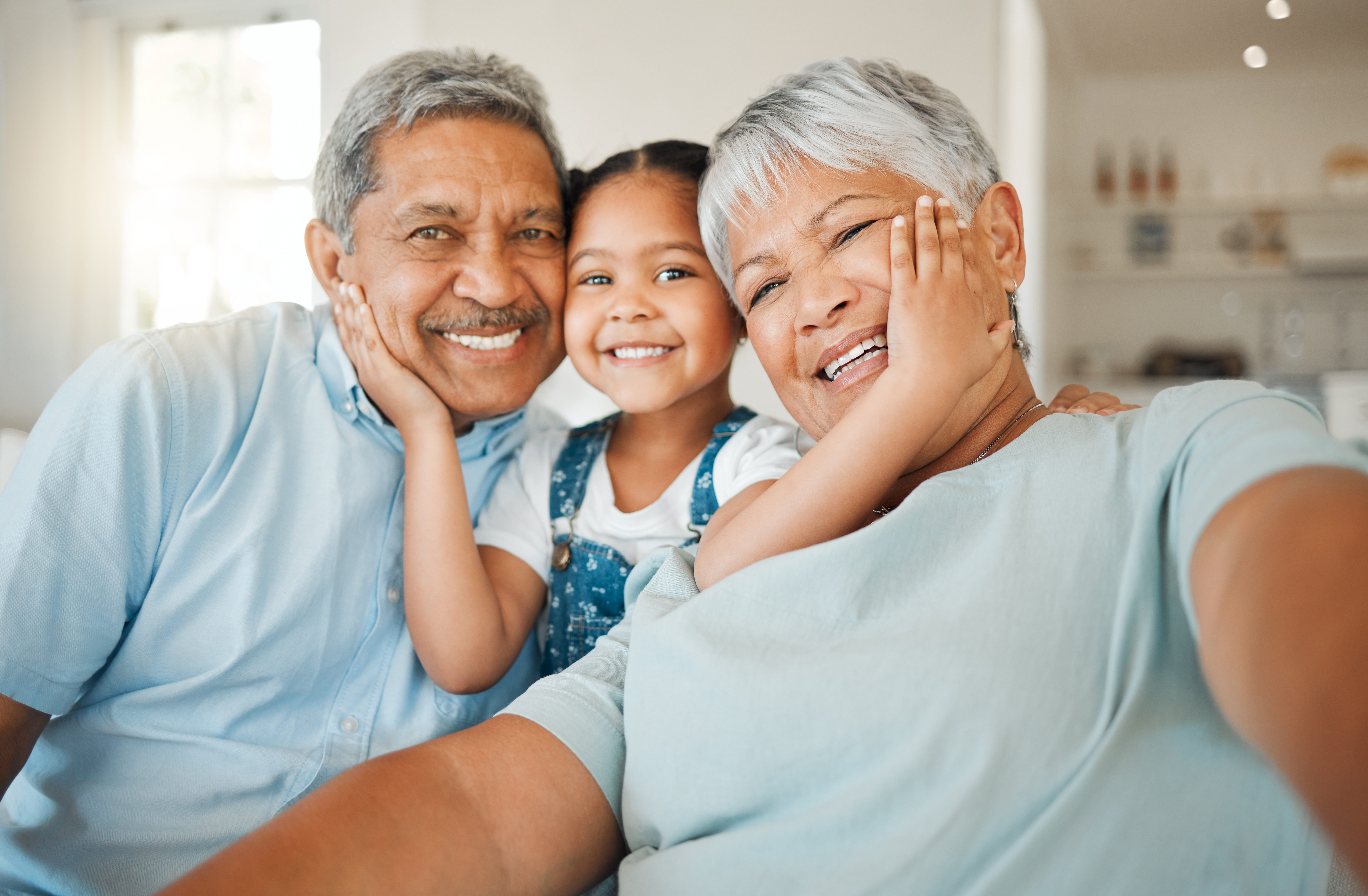 An older couple and their child smiling happily, radiating warmth and love in a heartwarming family moment.