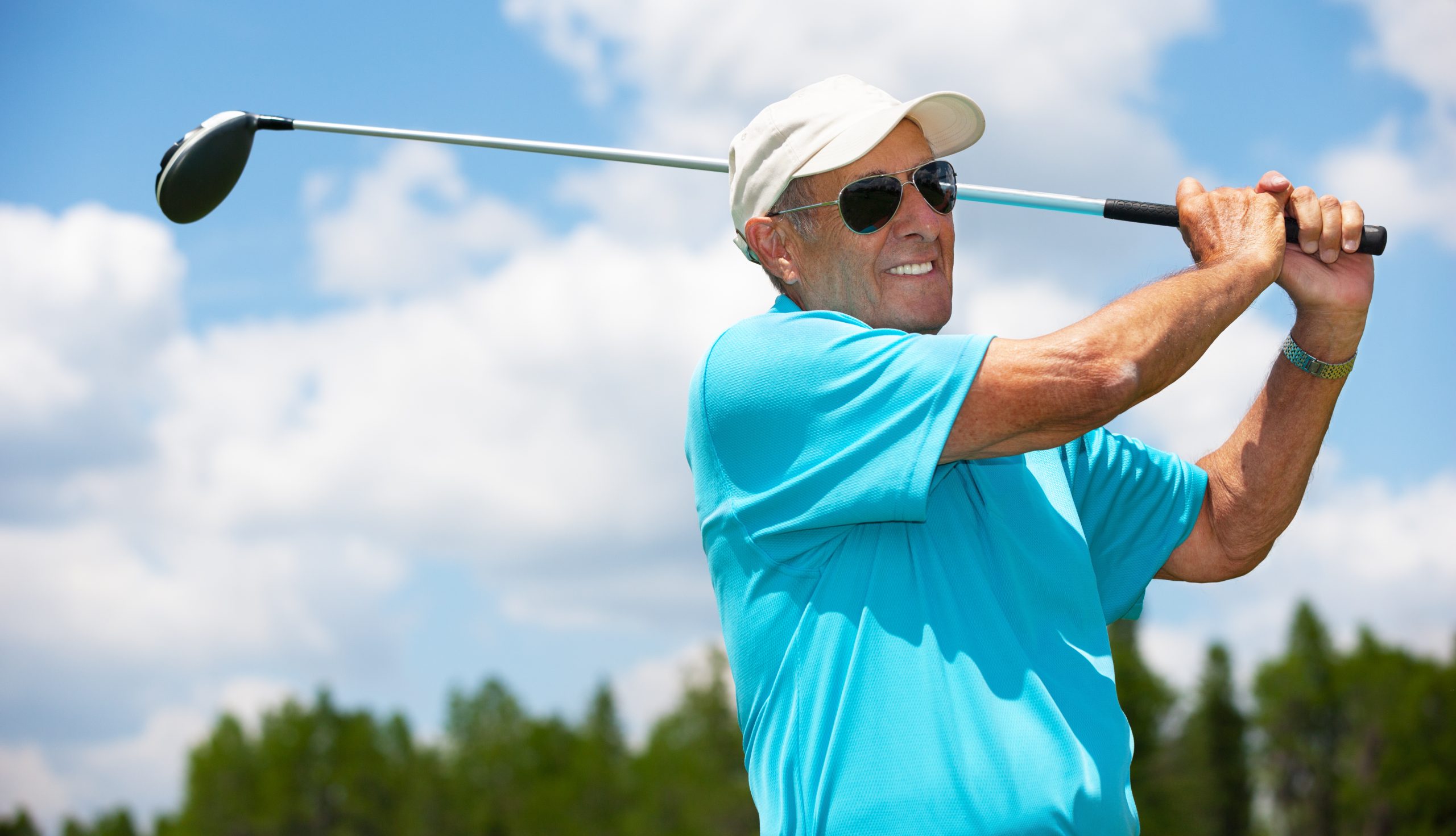 active elderly man playing golf with sunglasses