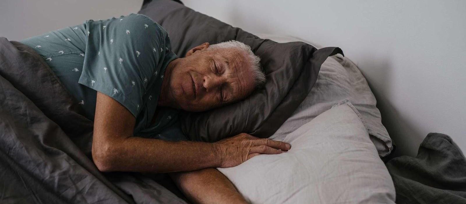 elderly man sleeping in his bed